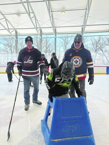 MELISSA MARTIN / FREE PRESS
Winnipeg Jets organization alumni Gerard McDonald and longtime NHL goalie Trevor Kidd, who is Métis from Oakbank, give skating tips to 12-year-old Savion Grieves, from Bunibonibee Cree Nation.