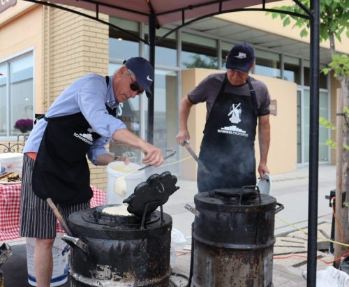 Volunteers serve our community at festival events by welcoming everyone and by serving wonderful waffles with white sauce.
