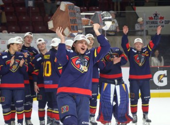 Marlen Edwards lifts the Centennial Cup into the air after helping the Niverville Nighthawks to a national championship. (Cassidy Dankochik The Carillon)