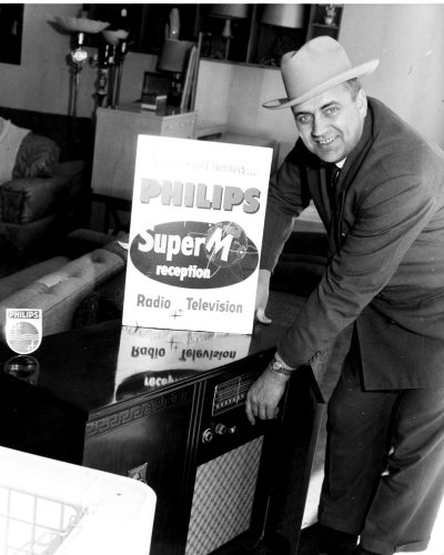 CARILLON ARCHIVES 

Joe Penner offers The Carillon News photographer a great deal on the Philips radio/television combo that helped him win a free European trip.