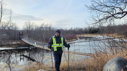 SUPPLIED
Mohammad Sajid Ali takes a moment with the Senkiw swinging bridge during his hike on the Crow Wing Trail.