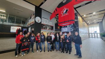 Niverville fans stand underneath a giant Hockey Canada jersey before the start of a game at the Centennial Cup. (Cassidy Dankochik The Carillon)
