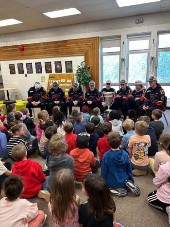 Niverville Nighthawks players present to students at Niverville Elementary School following their Turnbull Cup championship win. (Niverville Nighthawks Facebook)