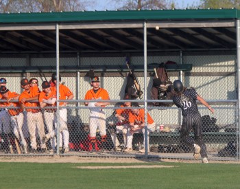 Carillon catcher Dayton Christianson tracks down a foul ball in front of the new-look dugouts at A.D. Penner Park while Winnipeg South players look on May 26. (Cassidy Dankochik The Carillon)