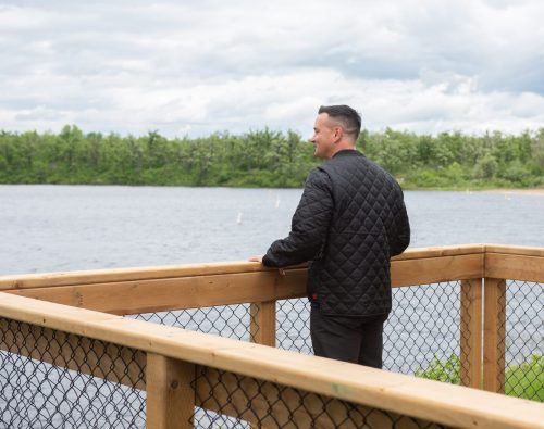 SVJETLANA MLINAREVIC THE CARILLON
Environment and Climate Change Minister Mike Moyes looks out onto the St Malo Lake on the dock of a mini-cain the province constructed on Sunset Shores Beach in St Malo Provincial Park after touring the 260 square-foot structure on June 12, 2026. The $115,000 cabin is one of six in construction by the province in St Malo with more to follow in the future.