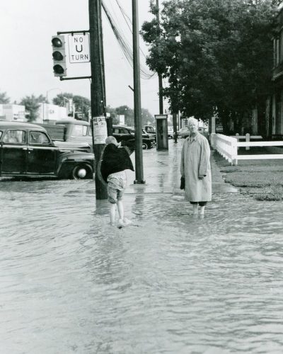 CARILLON ARCHIVES 

Ben H.W. Reimer gets set to wade through a river at Reimer Avenue and Main Street, while a young country music fan also braves the flood waters to get a closer look at a poster on a hydro pole, advertising Wilf Carter’s upcoming annual appearance at the La Broquerie Arena.