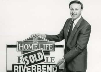 SCHINKEL PROPERTIES
Bob Schinkel is all smiles, nearly 50 years ago, as he hangs a “SOLD” banner on a Homelife Riverbend Realty sign after one of his earliest successful transactions in the 1980’s.