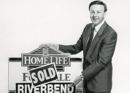 SCHINKEL PROPERTIES
Bob Schinkel is all smiles, nearly 50 years ago, as he hangs a “SOLD” banner on a Homelife Riverbend Realty sign after one of his earliest successful transactions in the 1980’s.
