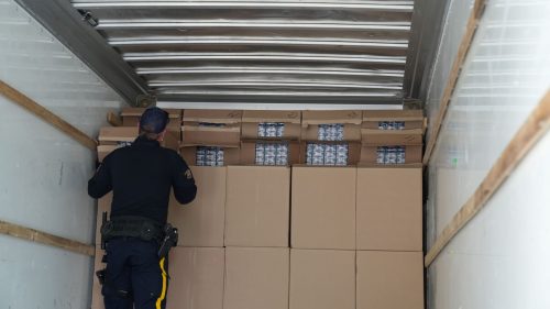 RCMP HANDOUT 

An officer examines part of the load of a semi carrying nearly 40,000 cartons of contraband cigarettes.