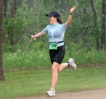Madison Vassart enjoys a downpour of rain as she closes out her finish during the Olympic distance triathlon at the 2026 St Malo Triathlon June 27. (Cassidy Dankochik The Carillon)