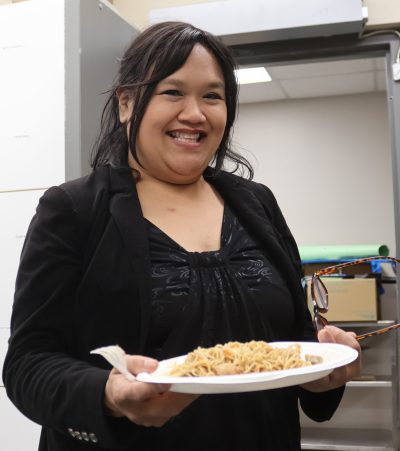 GRAHAM WALKER THE CARILLON 

Marylyn Martinez of the band YZZA enjoys a plate of Pancit Bihon noodles before her performance later that evening. Food preparation began early the previous day and included over 100 pounds of pork and chicken to feature in the Filipino delicacies.