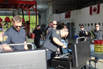 GRAHAM WALKER THE CARILLON 

Surrounded by fellow firefighters including Jordan Young, Chris Biddulph and station chief Steven Bowker, “Chief of Pancake Operations” Chad Swenarchuk tries to conceal the fact that the first batch of flapjacks “might have been overdone.”