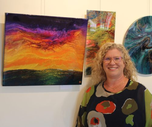 GRAHAM WALKER THE CARILLON 

Local artist, Tanya Penner, stands beside one of her favourite pieces as the colours exude a joyous vibrancy and the metallic elements of the resin draw the viewer into the canvas and provides their own individual experience.
