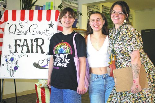 GRAHAM WALKER THE CARILLON 

Event co-organizer Marissa Wiebe (right) welcomes activists like Jordan Reimer (left) who makes a point of attending as many rural queer events as possible to show support. Like concert T-shirts, Jordan gets something for his wardrobe at each event such as the shirt worn here from the Pembina Valley Pride event.