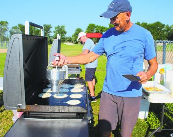 GRAHAM WALKER The Carillon 

“Chef-for-a-day” Mark Hildebrand takes over the batter dispenser from co-chef Randy Dyck to keep the hungry line flowing during the pancake breakfast put on by the Saturday Night Church in support of the Tache food bank.