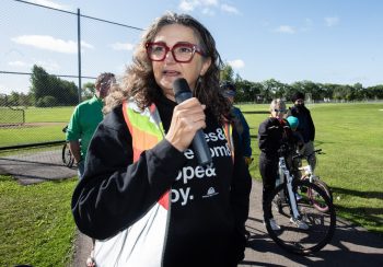 SVJETLANA MLINAREVIC THE CARILLON
Winnipeg's Bike Mayor Patty Wiens speaks to a large crowd in La Broquerie prior to a community bike ride on Sept. 13, 2026, starting at Tetrault Park. The La Broquerie trail system has 22 kilometres of trails that take walkers and cyclists through and out of the LUD. Wiens cycled five hours from Winnipeg to La Broquerie to participate in the ride.