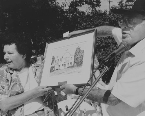 CARILLON ARCHIVES 

In this 1991 photo, George Gershman of the Manitoba Hotel Association, presents a plaque and a framed watercolor of the historic Tolstoi Hotel to Elsie Kolodzinski.