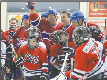 Members of the Montreal Canadiens alumni team and young players from the La Broquerie Habs minor hockey program get together for a group photo after their between-periods exhibition game. (Carillon Archives)