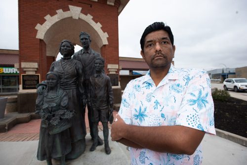SVJETLANA MLINAREVIC THE CARILLON 

City of Steinbach candidate Mitesh Kumar stands in front of Steinbach’s famed clock tower with the statues of immigrants who built Steinbach on Oct. 13. A hate banner was displayed by a neo-Nazi group on Tuesday, at the intersection of Highway 1 and Highway 12 leading into Steinbach that disparaged non-white candidates in the city’s election for a new council. Kumar and Greg Carlos are the only non-white candidates in the election.