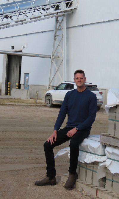 WES KEATING THE CARILLON 

As much as things may change, some things stay the same. A pallet of Barkman stone in the Steinbach yard still provides a Carillon photographer with a convenient place for a photo of the latest CEO with the plant in the background.