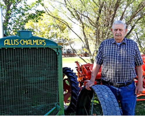 WES KEATING CARILLON ARCHIVES 

In this 2021 photo, Ben stands next to the pride of his collection, a 1929 Allis Chalmers 25-35, the last green tractor the company manufactured, before switching to orange in 1930.