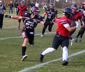 Andrew Barrett tugs at the jersey of a Sisler player during WHSFL action in Oakbank Oct. 22. (Cassidy Dankochik The Carillon)