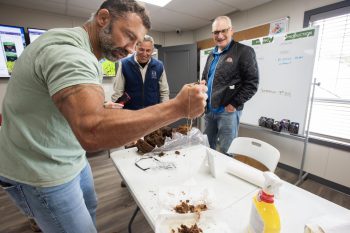 SVJETLANA MLINAREVIC THE CARILLON
Water pours out of the fist of FPM Peat Moss Co. Ltd. general manager Clayton Grawberger as he shows the moisture in a small sample of raw peat moss from a core taken directly from a bog to smiling Forest Tour guide Bob Austman and Coun. Mark Bernard during an RM of Piney Forest Tour to the plant on Sept. 18, 2026.